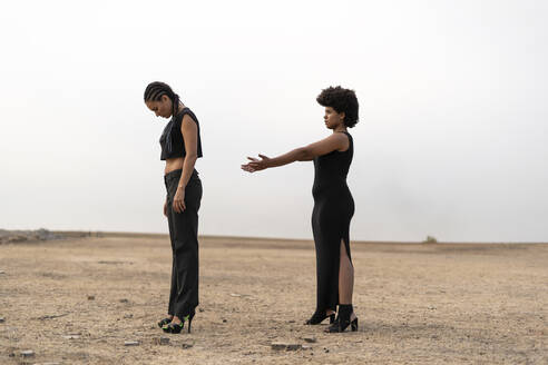 Zwei schwarz gekleidete Frauen stehen in einer düsteren Landschaft - ERRF01944