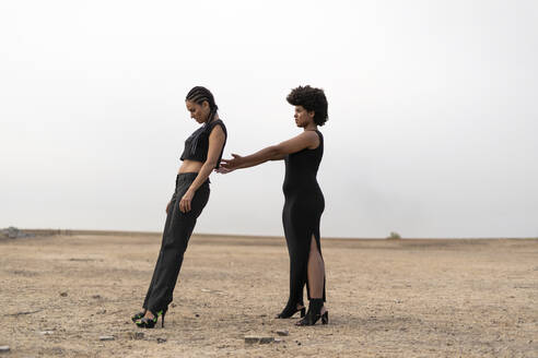Zwei schwarz gekleidete Frauen in düsterer Landschaft - ERRF01945