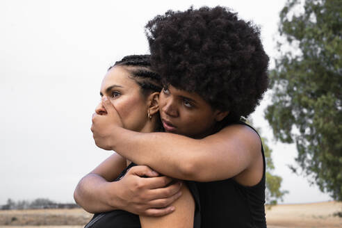 Woman covering mouth of other woman with her hand - ERRF01954