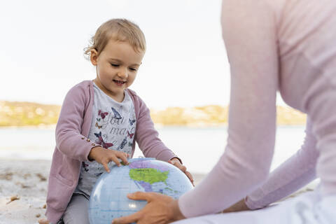 Portrait of little girl looking at Earth beach ball stock photo