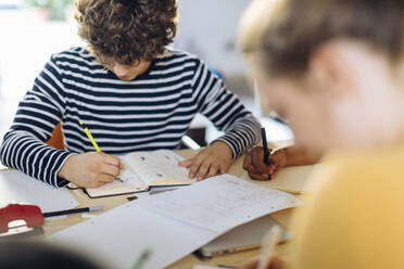 Young people sitting together at table and taking notes - SODF00141