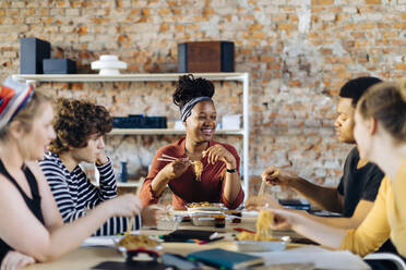 Young people sitting together at table having lunch break - SODF00153