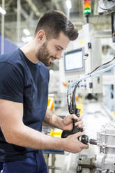 Ein Mann arbeitet in einer modernen Fabrik - WESTF24262