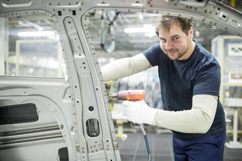 Porträt eines selbstbewussten Mannes, der in einer modernen Autofabrik arbeitet, lizenzfreies Stockfoto