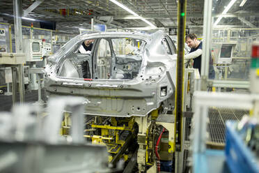 Two colleagues working in modern car factory - WESTF24331