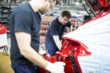 Zwei Kollegen arbeiten in einer modernen Autofabrik - WESTF24354