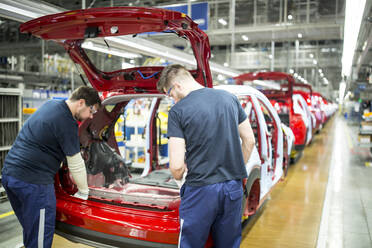 Zwei Kollegen arbeiten in einer modernen Autofabrik - WESTF24355