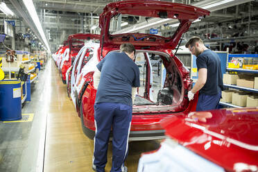 Zwei Kollegen arbeiten in einer modernen Autofabrik - WESTF24357