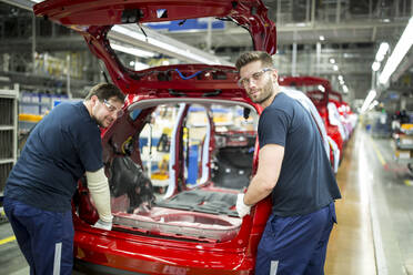Zwei Kollegen arbeiten in einer modernen Autofabrik - WESTF24358