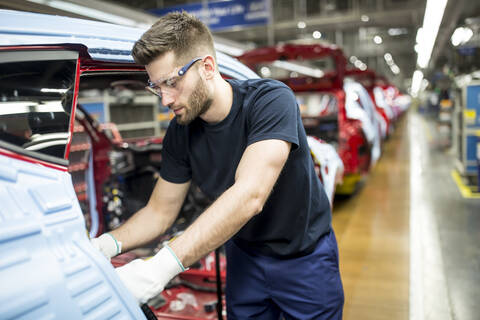 Mann arbeitet in einer modernen Autofabrik, lizenzfreies Stockfoto