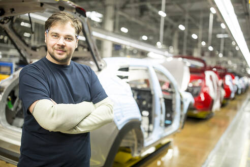 Porträt eines selbstbewussten Arbeiters in einer modernen Autofabrik - WESTF24370