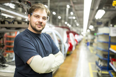 Porträt eines selbstbewussten Arbeiters in einer modernen Autofabrik - WESTF24371