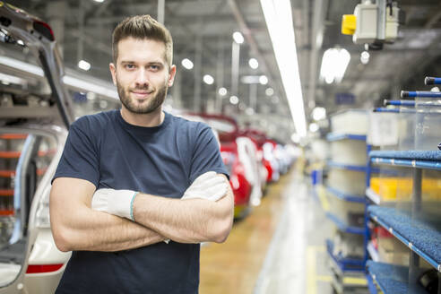 Porträt eines selbstbewussten Arbeiters in einer modernen Autofabrik - WESTF24372