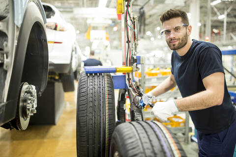 Porträt eines selbstbewussten Mannes, der in einer modernen Autofabrik arbeitet, lizenzfreies Stockfoto