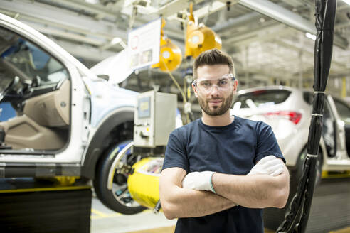 Porträt eines selbstbewussten Arbeiters in einer modernen Autofabrik - WESTF24385