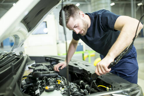 Mann arbeitet an einem Auto in einer modernen Fabrik - WESTF24393