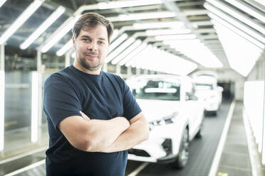 Portrait of confident worker in modern car factory - WESTF24399