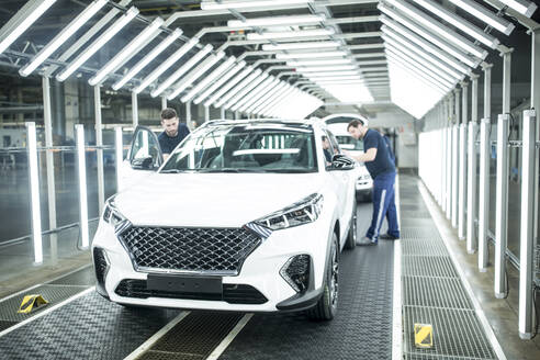 Two colleagues working in modern car factory - WESTF24409