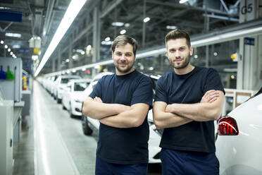 Portrait of confident colleagues in modern car factory - WESTF24413