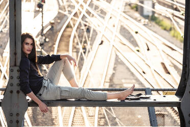 Young woman sitting on Hacker bridge at sunset, Munich, Germany - WFF00127