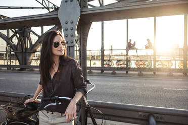 Junger Radfahrer auf einer Brücke bei Sonnenuntergang - WFF00133