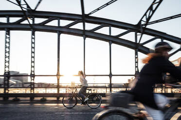 Junger Radfahrer auf einer Brücke bei Sonnenuntergang - WFF00138