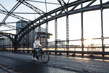 Junger Radfahrer auf einer Brücke bei Sonnenuntergang - WFF00140