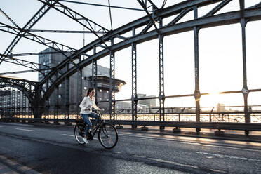 Young cyclist on a bridge at sunset - WFF00140