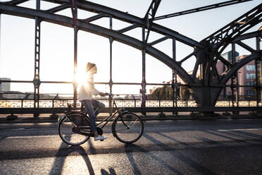 Junger Radfahrer auf einer Brücke bei Sonnenuntergang - WFF00141