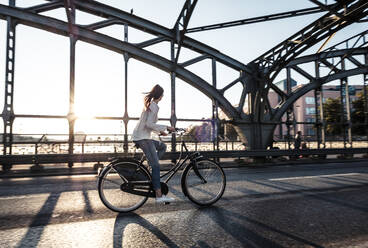 Young cyclist on a bridge at sunset - WFF00142