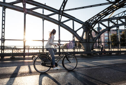 Junger Radfahrer auf einer Brücke bei Sonnenuntergang - WFF00142