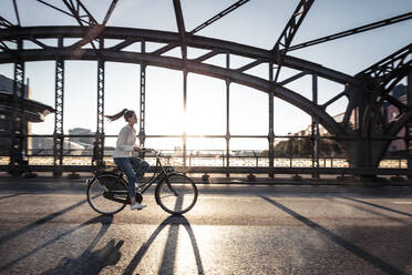 Junger Radfahrer auf einer Brücke bei Sonnenuntergang - WFF00143