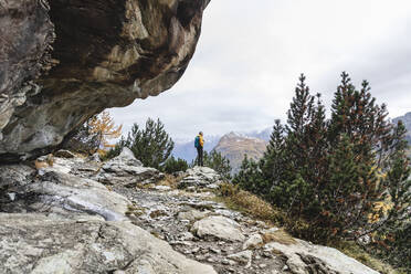 Wanderer steht und blickt über eine Hochebene im Herbst, Sondrio, Italien - MCVF00066