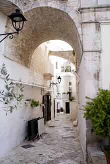 Italy, Puglia, Locorotondo, Alley and arch in old town - HLF01188