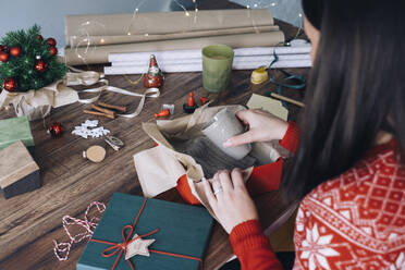 Woman's hands packing Christmas present - MOMF00793