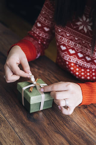 Frauenhände beim Verzieren von Weihnachtsgeschenken, lizenzfreies Stockfoto