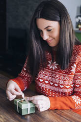 Frau dekoriert Weihnachtsgeschenk - MOMF00803