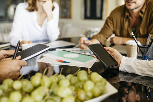 Nahaufnahme von Mitarbeitern, die gemeinsam an einem Tisch arbeiten - JRFF03830