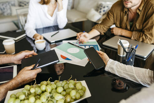 Nahaufnahme von Mitarbeitern, die gemeinsam an einem Tisch arbeiten - JRFF03832