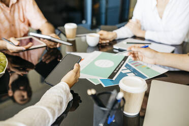 Nahaufnahme von Mitarbeitern, die gemeinsam an einem Tisch arbeiten - JRFF03833