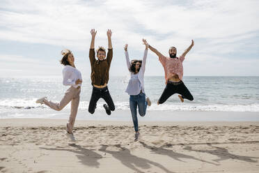 Exuberant friends jumping on the beach - JRFF03846