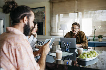 Friends working together on table at home - JRFF03875