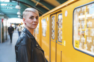 Porträt einer am Bahnsteig stehenden Frau, Berlin, Deutschland - WPEF02246