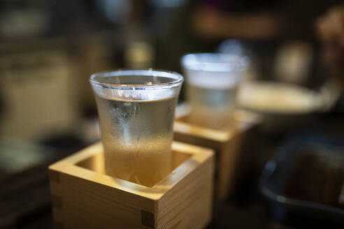 Japan, Takayama, Sake served in masu in traditional Japanese restaurant - ABZF02709