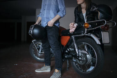 Ehepaar mit Oldtimer-Motorrad in der Garage - JPIF00237