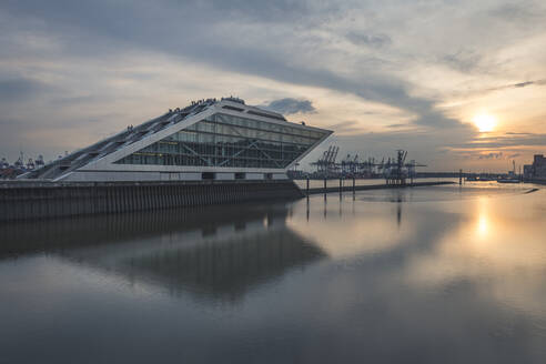 Deutschland, Hamburg, Altona, Modernes Bürogebäude im Hafenbecken bei Sonnenaufgang - KEBF01415