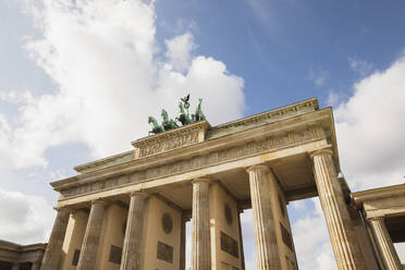 Deutschland, Berlin, Niedriger Blickwinkel auf das Brandenburger Tor gegen Wolken stehend - GWF06243