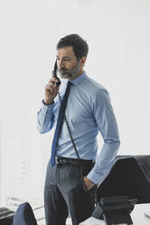 Serious mature businessman on the phone in office - MOEF02546