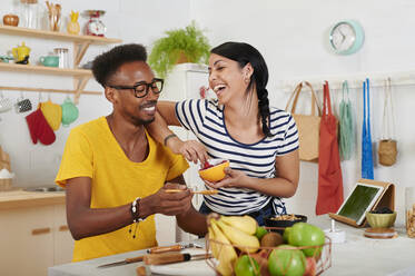 Multiethnic couple breakfasting together in the kitchen - IGGF01399