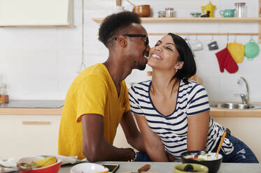 Multiethnic couple breakfasting together in the kitchen - IGGF01411